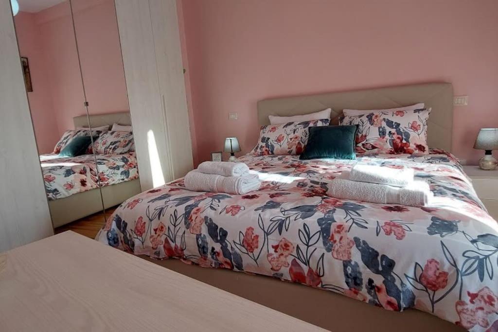 a bedroom with two beds and a large bed at Cozy sunlit apartment with scenic balcony view in Tirana