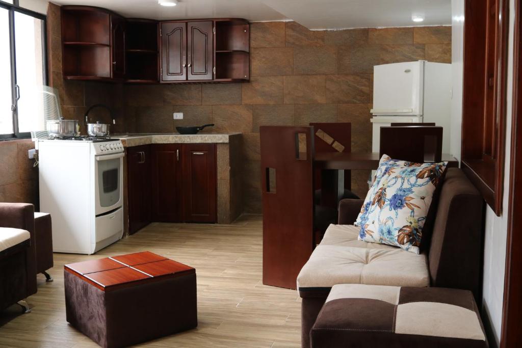a living room with a couch and a kitchen at Hospedaje Vacacional y Familiar Baños in Baños