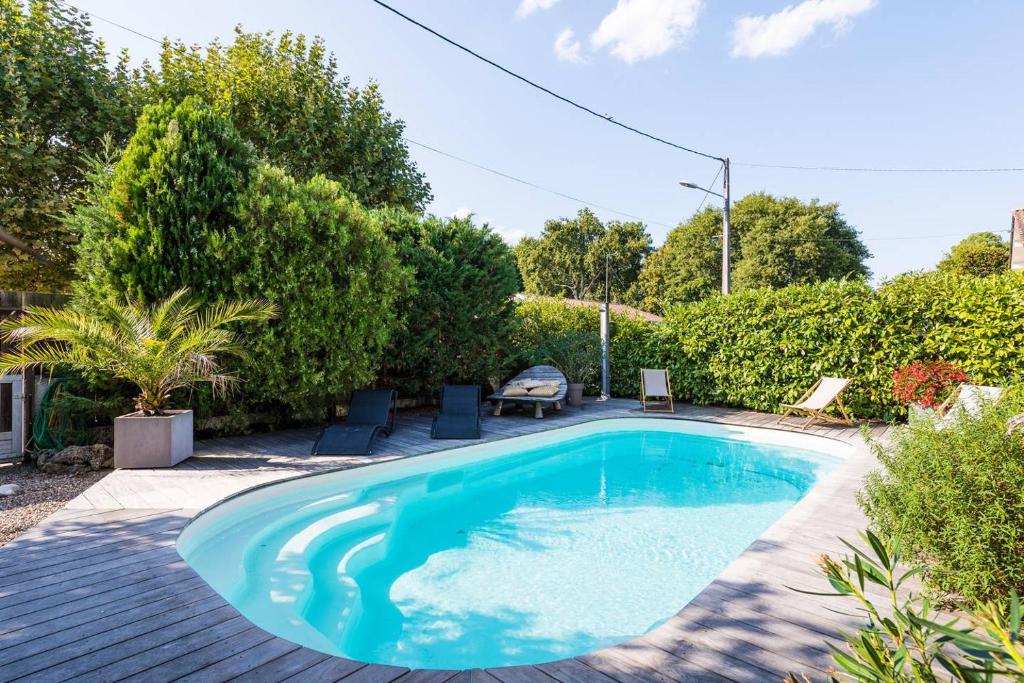 a swimming pool in a yard with trees at Villa Cap Ferret in Lège-Cap-Ferret