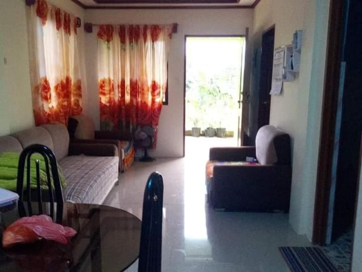sala de estar con sofá y ventana en Little bridges mini bar and rooms, en Mambajao