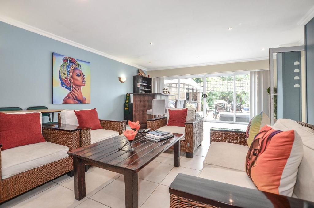 a living room with couches and a table at Atlantic Breeze in Cape Town