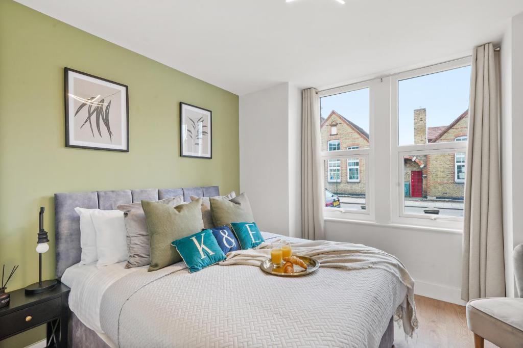 1 dormitorio con 1 cama grande y ventana en Fabulous Wimbledon 3 Bed Apartment with Outside Space, en Londres