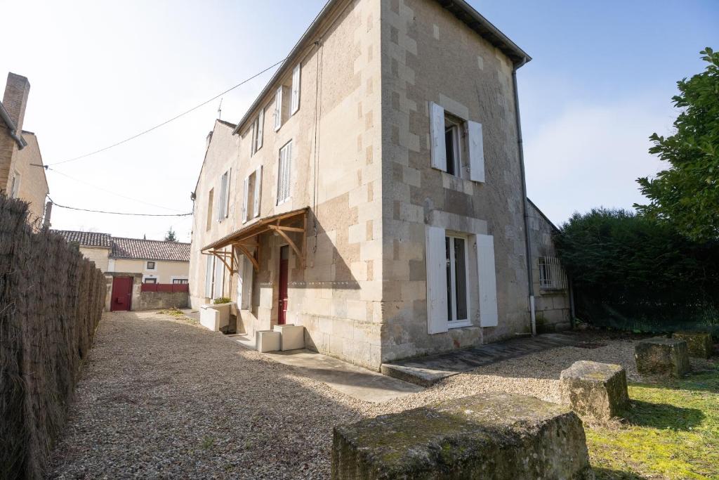 un grande edificio in pietra con piano aventh di LaConciergerieJonzac, Maison de Ville La Coquette a Jonzac