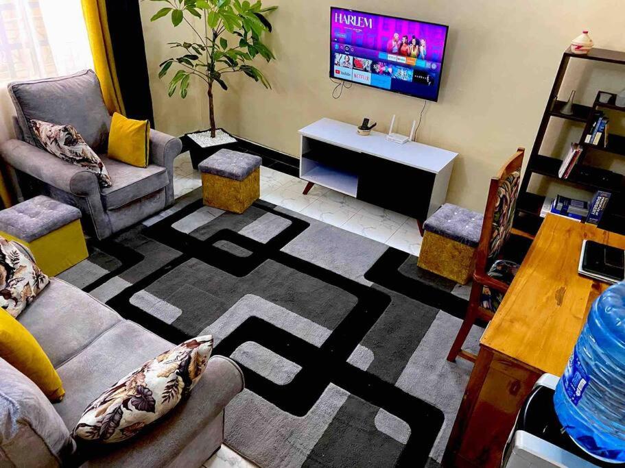 a living room with a couch and a tv at Splendid stay in Nakuru in Nakuru