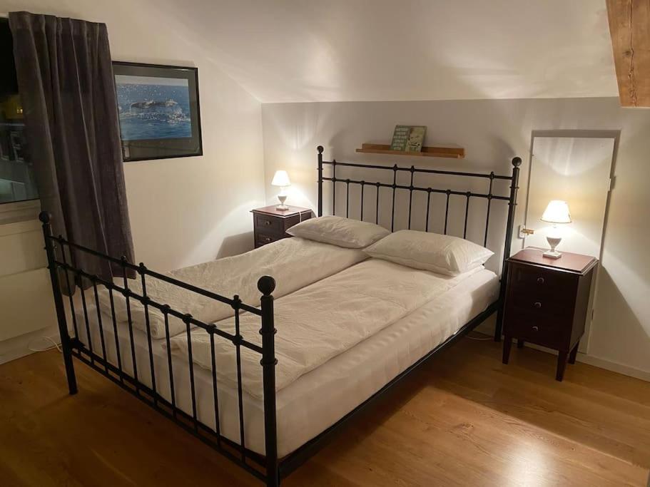 ein Schlafzimmer mit einem großen Bett mit zwei Nachttischen in der Unterkunft Rooftop view apartment in Vardø