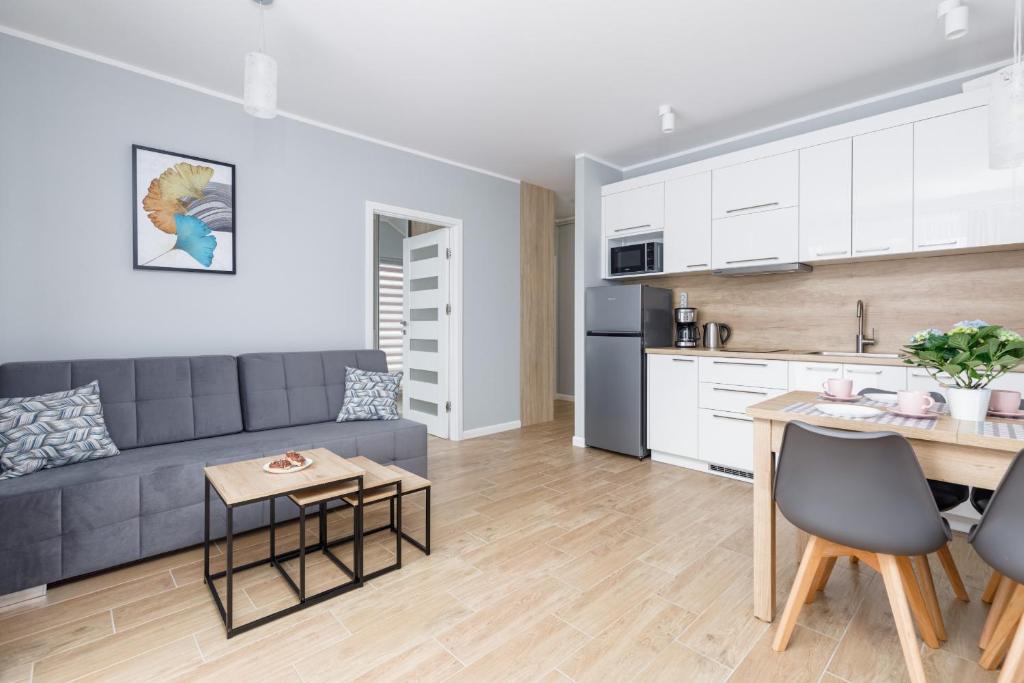 a living room with a couch and a table at Apartment Rybacka with Parking&Balcony by Renters in Międzywodzie