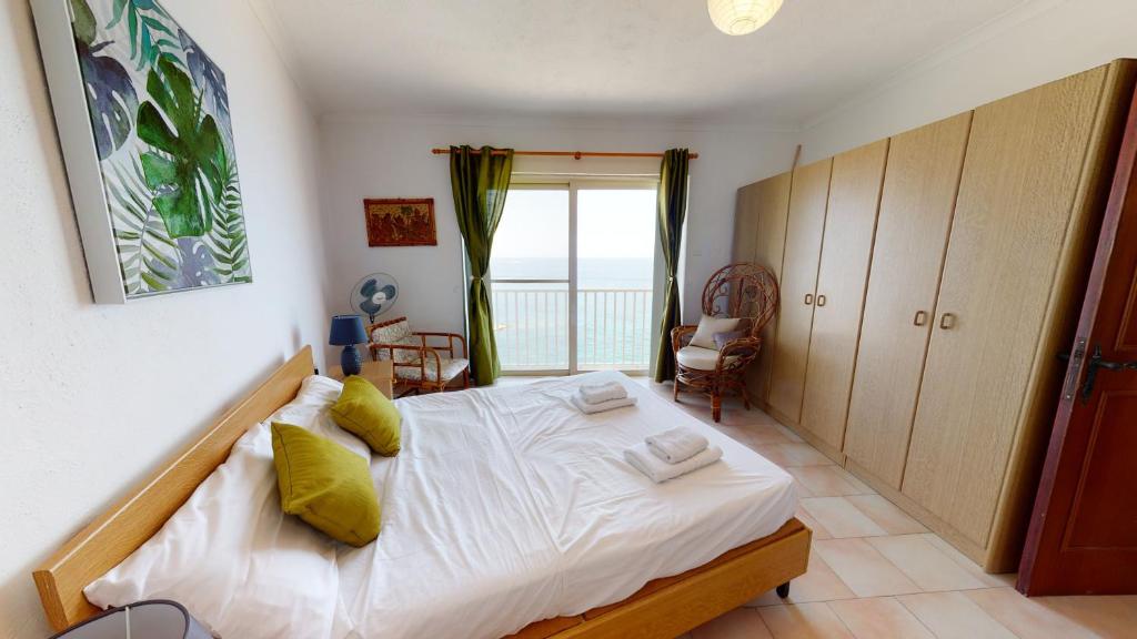 um quarto com uma grande cama branca e uma janela em 6th floor seafront apartment with open sea views em Sliema
