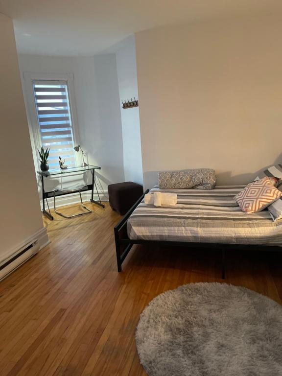 a room with a bed and a couch and a table at AUBERGE et BISTRO NAMASTÉ in Lachute