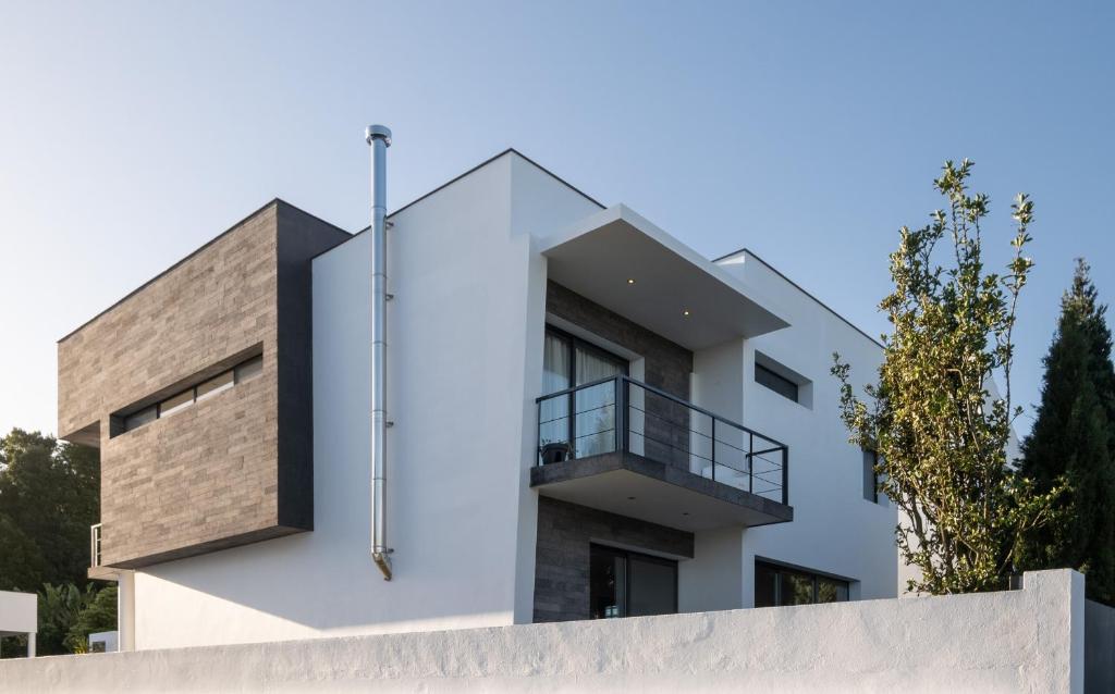 Una casa blanca con un balcón en el lateral. en Azores Green Woods Villa, en São Vicente Ferreira