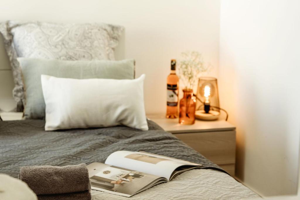 Dormitorio con cama con libro y lámpara en Beautiful 2 bed in center Sliema near beach, en Sliema