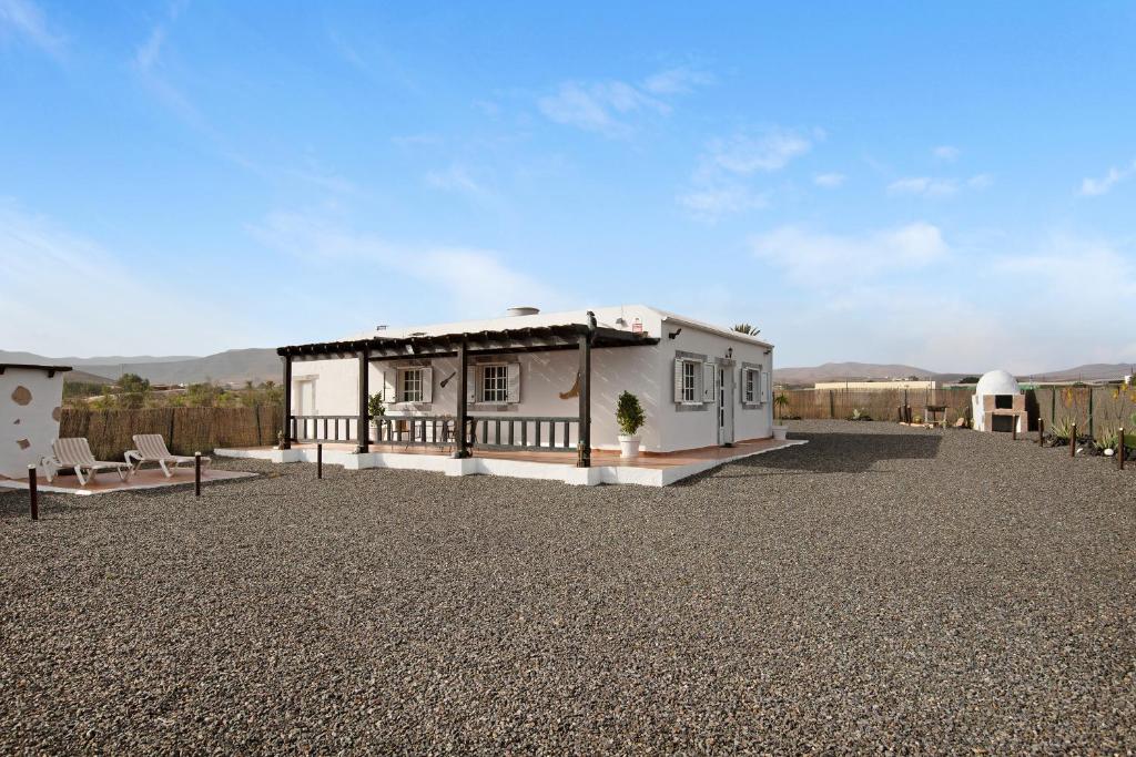 a small white house with a gravel yard at Casa Majos in Tesejerague