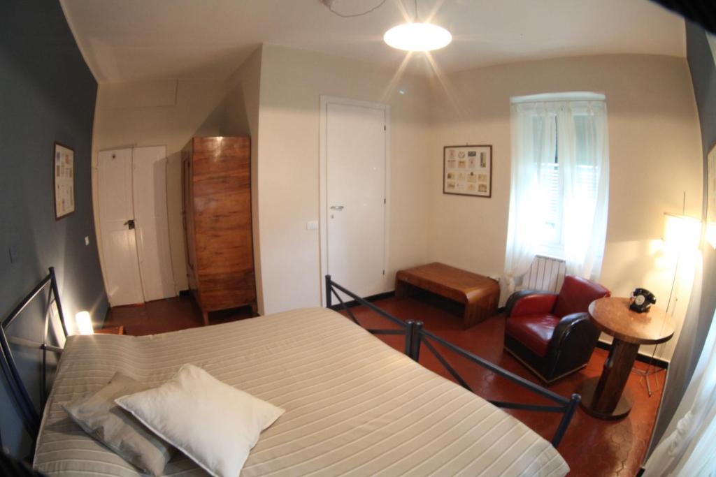 a bedroom with a bed and a red chair at BBQ Lodge in Camogli