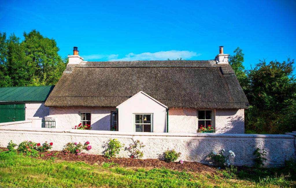 a cottage with a thatched roof on a hill at Killee Cottage in Mitchelstown