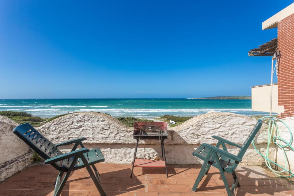 プトゥツ・イドゥにあるAppartamento Con Terrazza Sul Mareの海を背景にしたパティオ(椅子2脚付)
