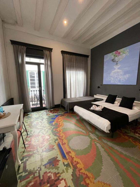a bedroom with two beds and a large rug at Madison Rooms in Sitges