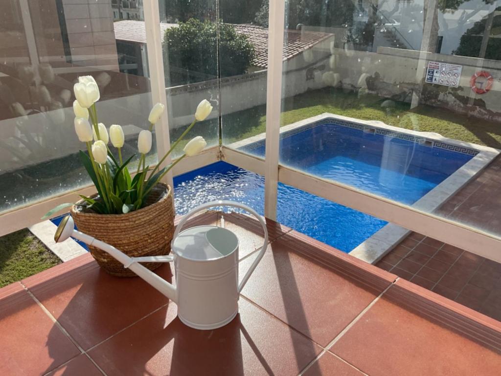 een tafel met een waterbak en bloemen op een balkon bij Apartamento Paris I in Miami Platja