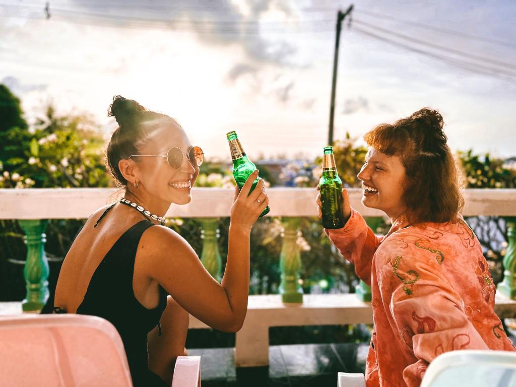 twee vrouwen die flessen bier omhoog houden bij The Funky Monkey Hostel in Haad Rin