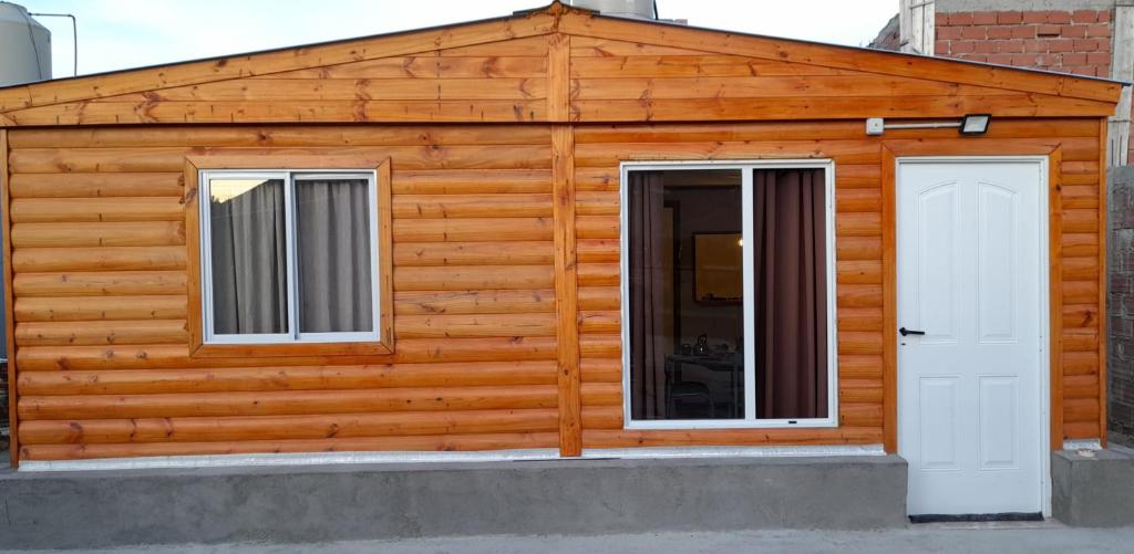 a wooden cabin with two windows and a door at M&M ll in Comodoro Rivadavia
