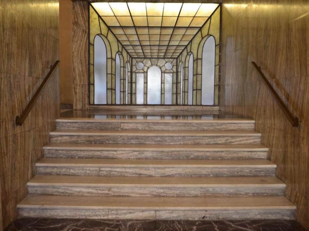 een hal met een trap en glas-in-loodramen bij Central City Genova in Genua