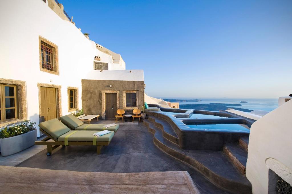 a rooftop patio with a view of the ocean at Sophia Luxury Suites in Imerovigli