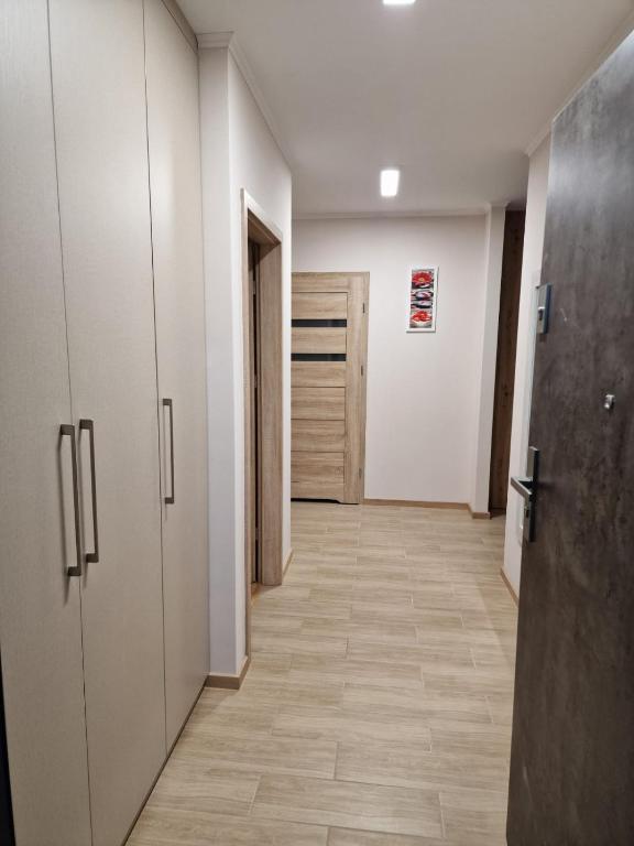 a hallway with white cabinets and a hallway with a door at Vintage apartament in Olsztyn