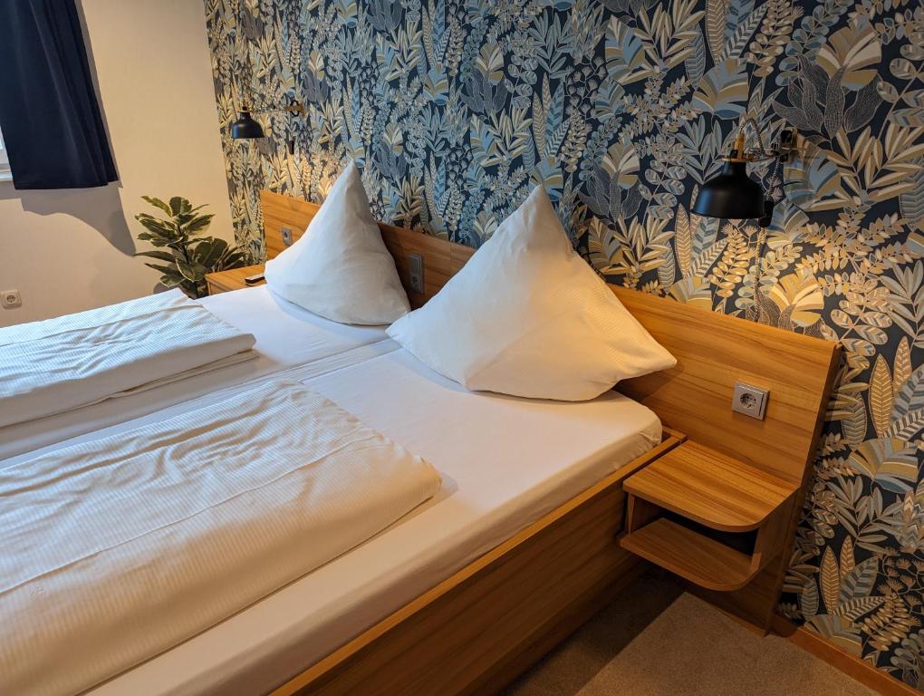 a bed with two pillows on it in a room at PaGa - Parkgaststaette in Ehrenburg