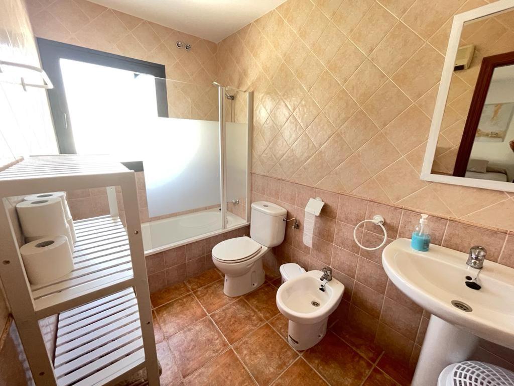 a bathroom with a toilet and a sink at LA CASITA DE EL BOSQUE in El Bosque