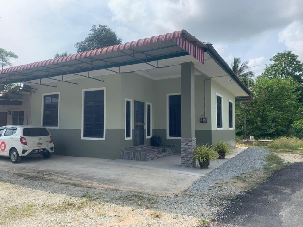 a small house with a car parked in front of it at Homestay Cikgu Fatiah in Kota Bharu