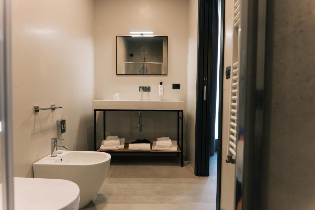 レッチェにあるArryvo Hotelの洗面台、トイレ、鏡のあるバスルーム