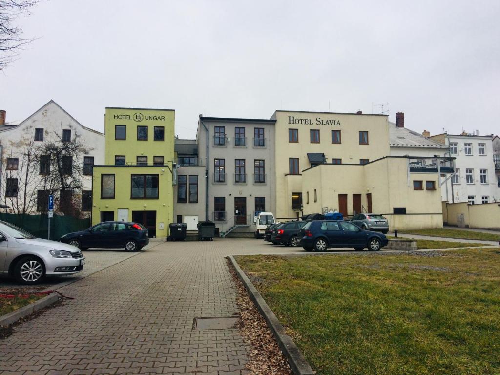 grupa budynków z samochodami zaparkowanymi na parkingu w obiekcie Hotel Slavia w mieście Svitavy