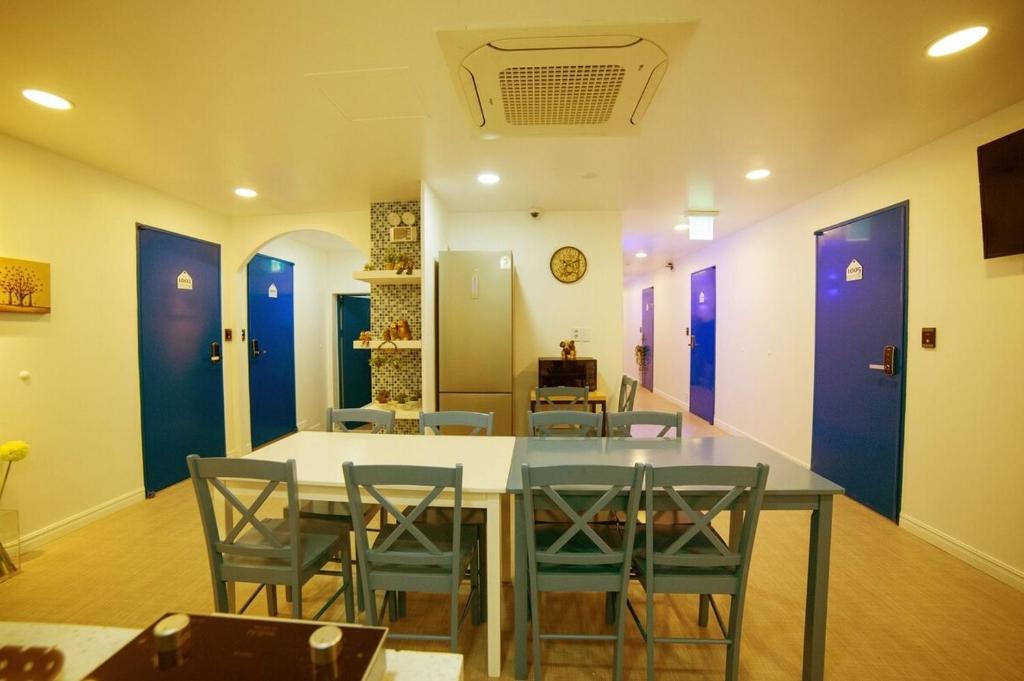 a dining room with a table and chairs and purple doors at Stay in Blue in Seoul