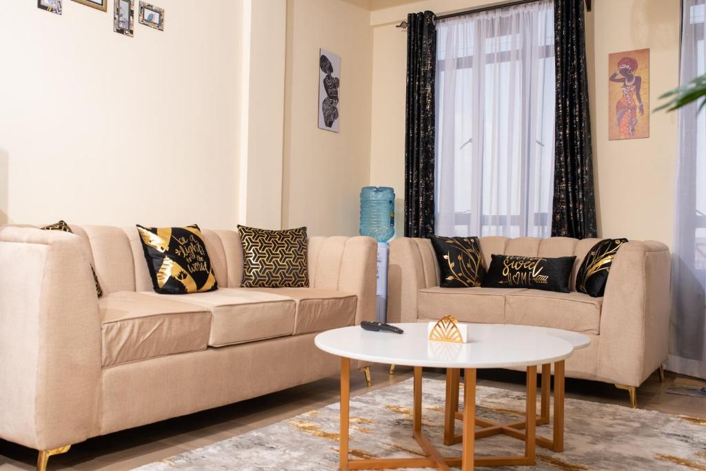 a living room with two couches and a table at Luxury 1Br Apartment with Secure Parking & Lift Nakuru in Nakuru
