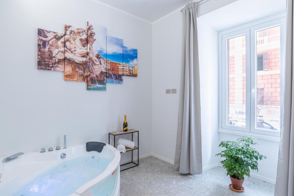 een witte badkamer met een bad en een raam bij White Home Suite and Rooms in Rome
