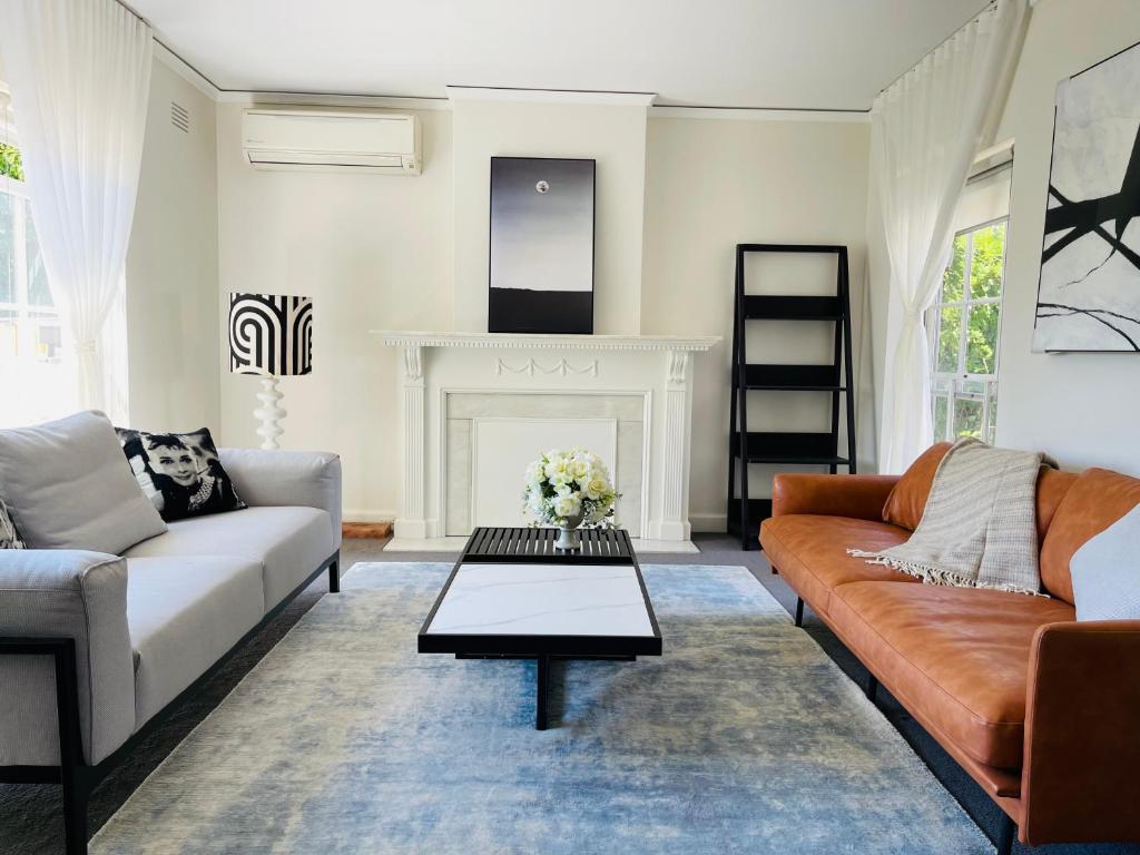 sala de estar con 2 sofás y chimenea en ToorakwhiteHouse3GrandKingBedrooms1BigGarden, en Melbourne