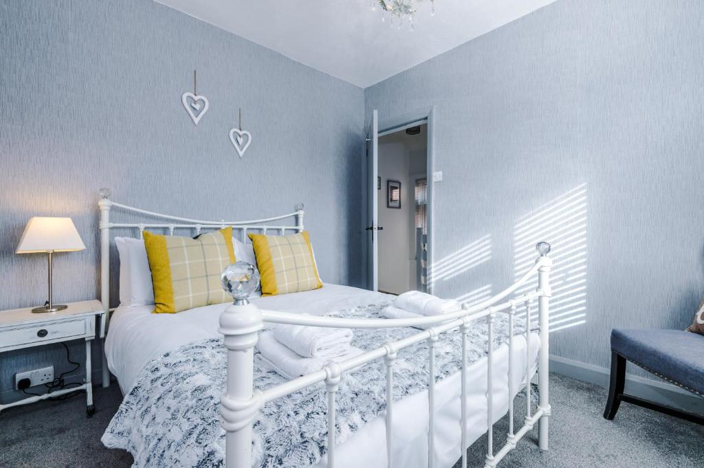 1 dormitorio con cama blanca y pared azul en Prenton House en Chester