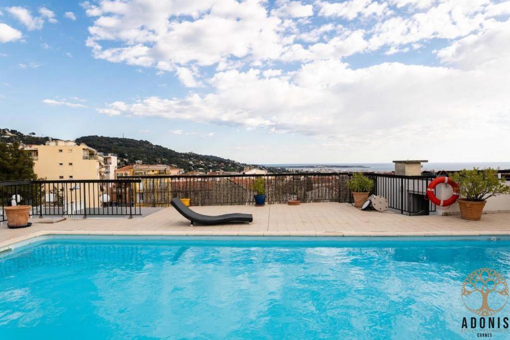 a swimming pool on the roof of a building at Adonis Cannes - Hôtel Thomas in Le Cannet