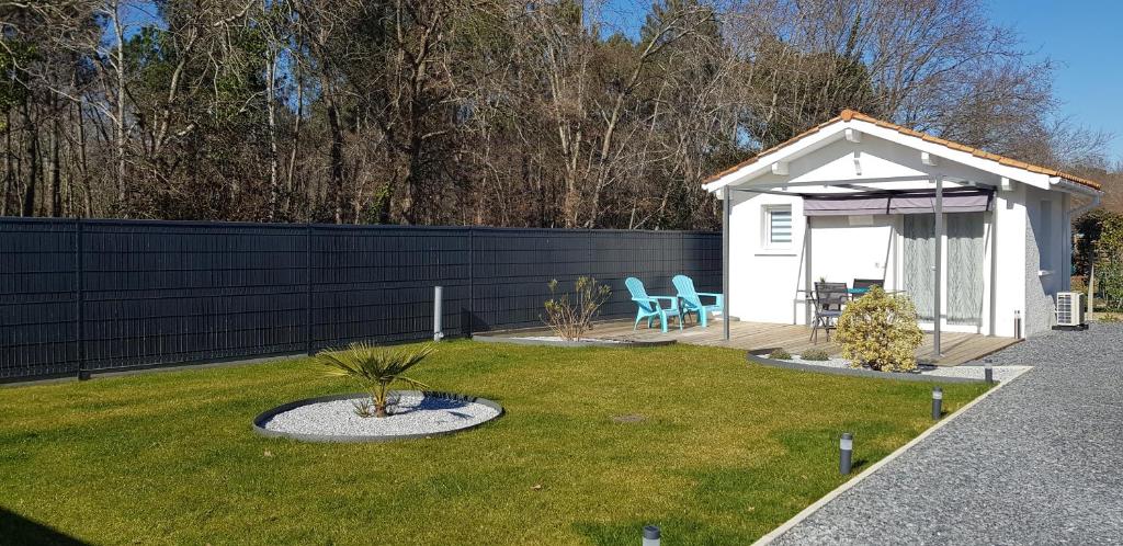 a small shed with a table and chairs in a yard at Chambre d'hôtes Entre-deux Lacs in Biscarrosse