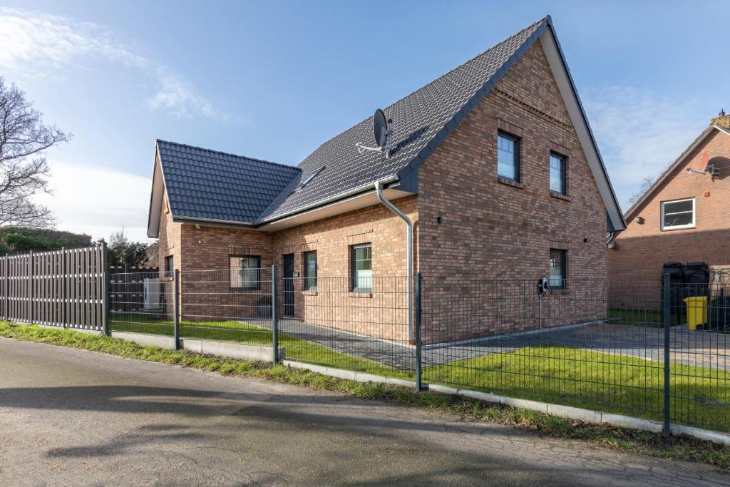 a brick house with a black roof at Hooge in Hattstedt