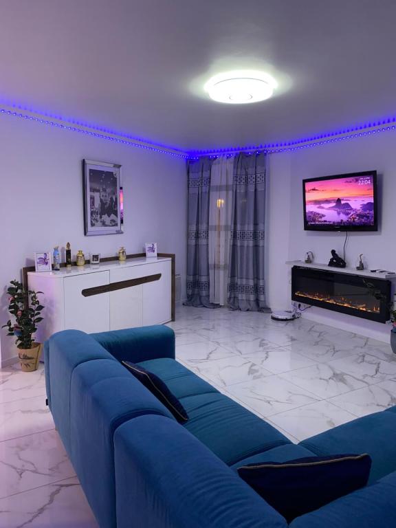 sala de estar con sofá azul y TV en appartement luxueux 70m2, 2 chambres, en Argenteuil