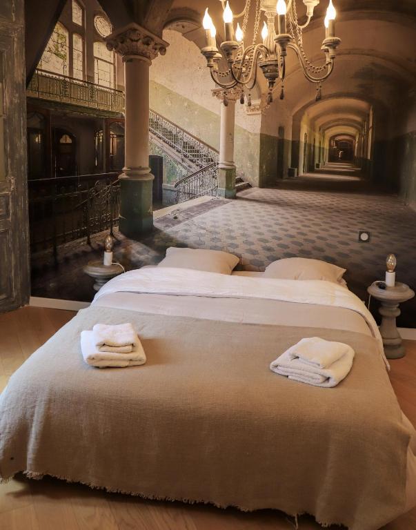 - 2 lits dans une grande chambre avec des serviettes dans l'établissement C’est l’app’Art! Pau centre, à Pau