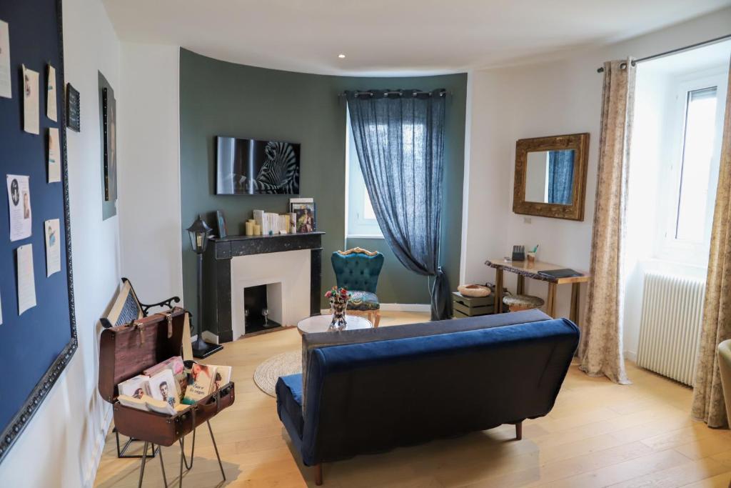ein Wohnzimmer mit einer blauen Couch und einem Kamin in der Unterkunft C’est l’app’Art! Pau centre in Pau