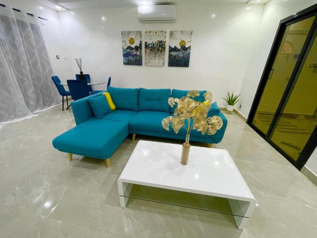 a living room with a blue couch and a table at Room in Apartment - Grande Chambre Avec Toilette Integrees in Dakar