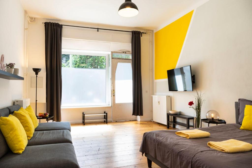 - un salon avec un canapé et une télévision dans l'établissement Cosy Apartment plus Self Checkin plus free Street parking, à Berlin