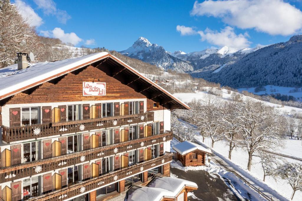 un chalet en las montañas en la nieve en Hotel Le Bois Joli, en Bernex