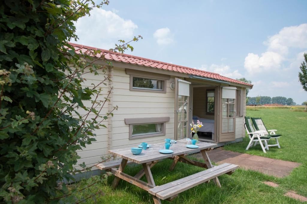 a tiny house with a picnic table in the yard at Oud Drimmelen in Drimmelen