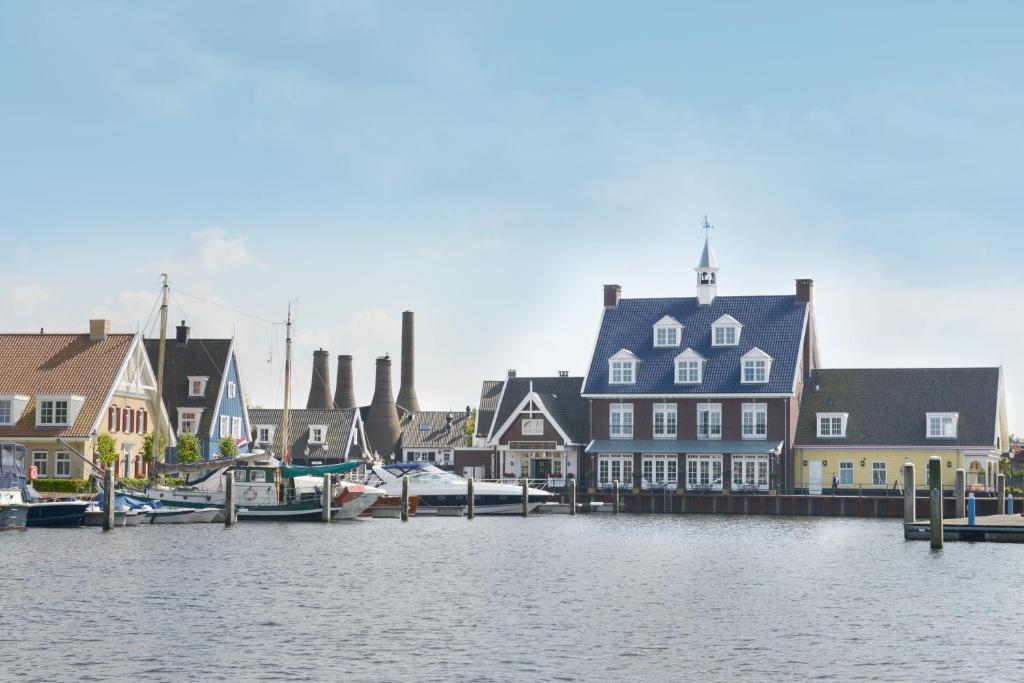 un grupo de casas y barcos en un puerto en Fletcher Hotel - Restaurant Nautisch Kwartier en Huizen