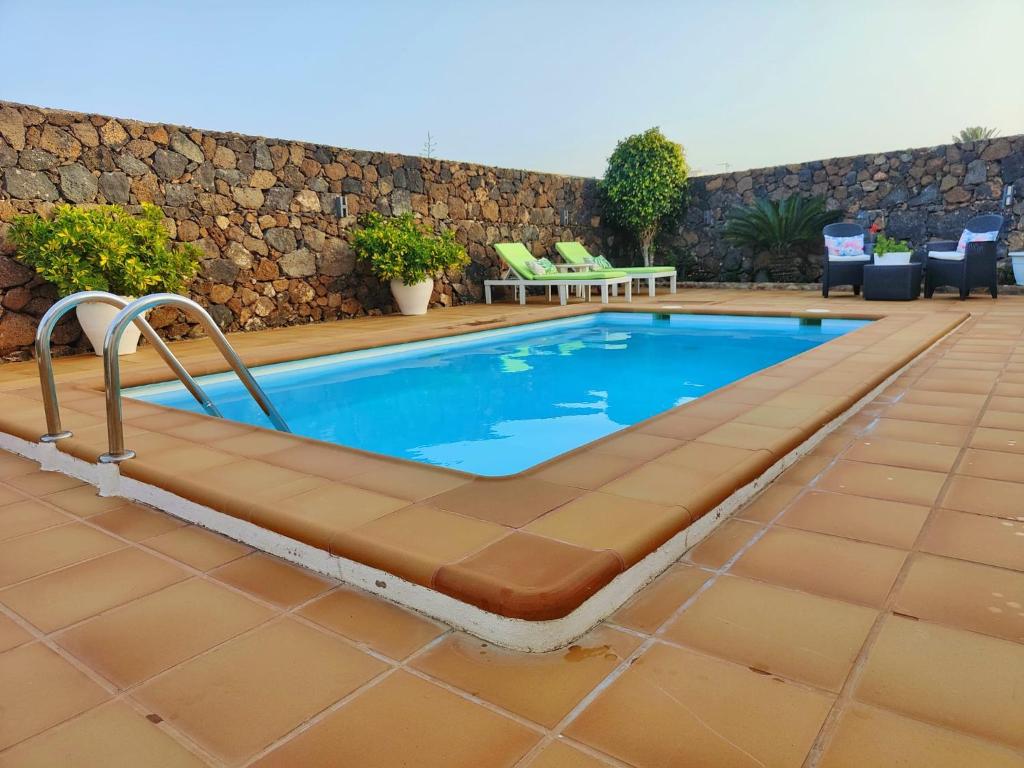 una piscina con un banco junto a una pared en Villa Jardín Atteneri, en La Vegueta