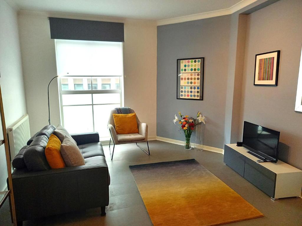 a living room with a couch and a television at Heart of the city. Perfect for attractions & West End in London