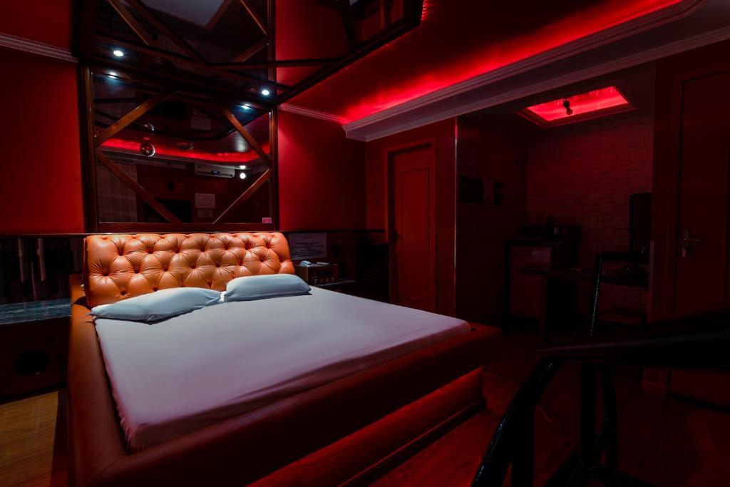 a bed in a room with a red light at Motel Kaskata in Santa Cruz do Sul