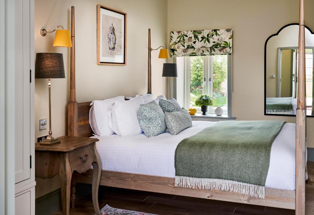 um quarto com uma cama, uma mesa e uma janela em The Montagu Arms em Beaulieu